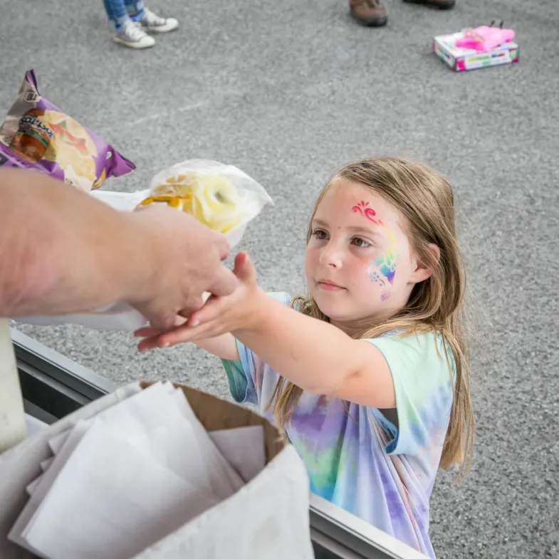 Little girl receives food from a summer meal site