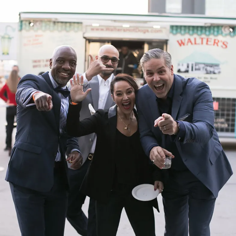 A group of attendees pose outside of a food truck at NYC's Taste of the Nation event