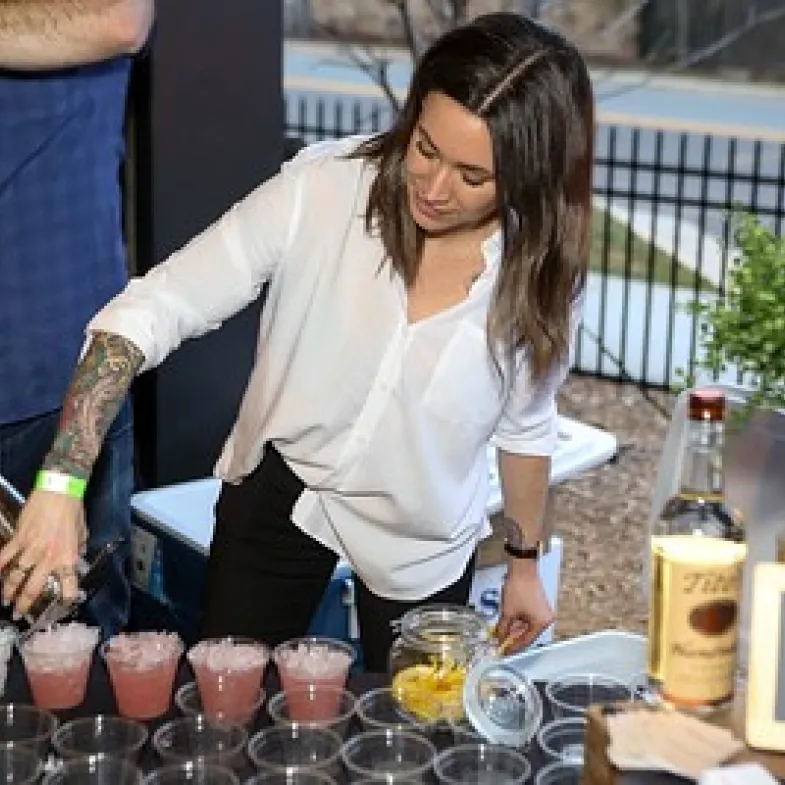 A mixologist pouring drinks at a No Kid Hungry event
