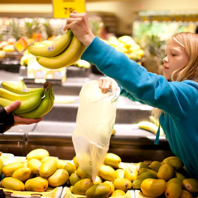 A child picks out bananas at a grocery store