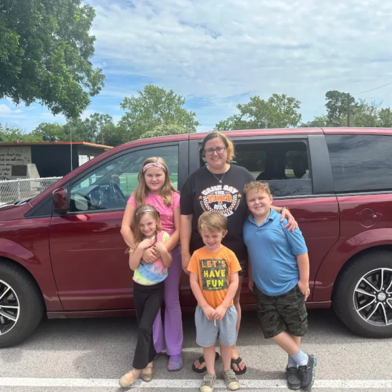 White family in front of red car (1 mom 3 kids)