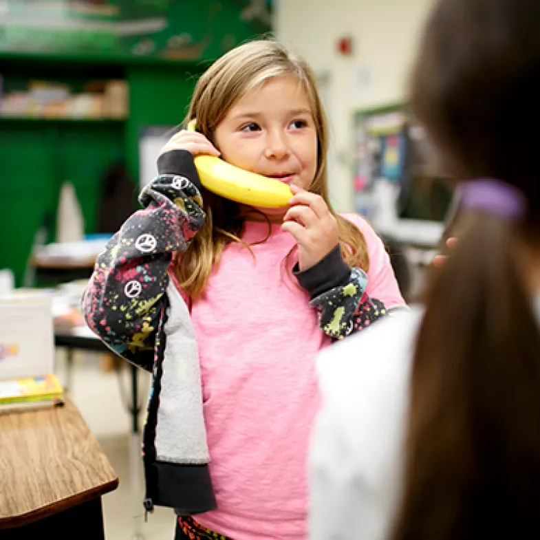 Girl pretending to talk on a banana phone