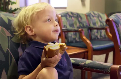 Kid eating croissantwich