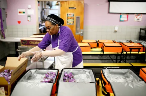 A cafeteria worker preparing breakfast