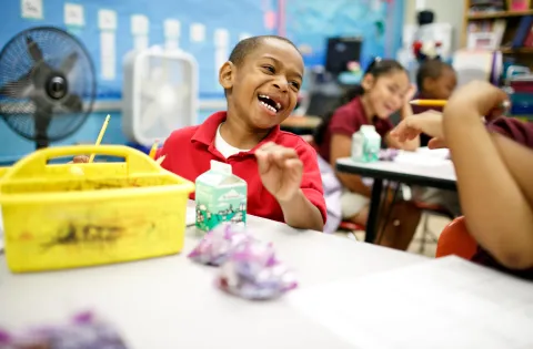 A little boy really digging breakfast in the classroom