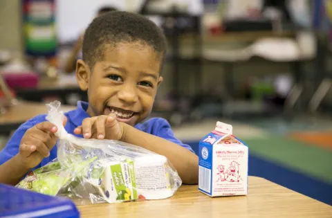 A little boy eating school breakfast