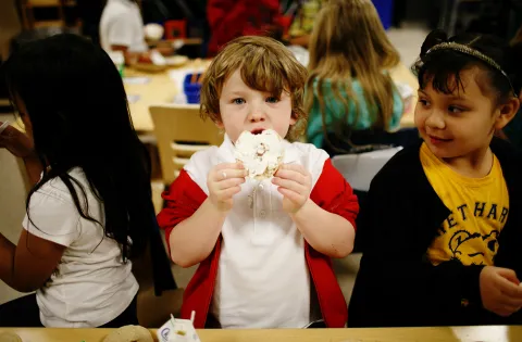 A little boy eating breakfast at school 