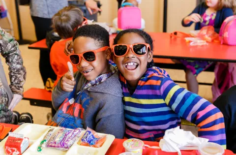 Happy kids wearing No Kid Hungry sunglasses