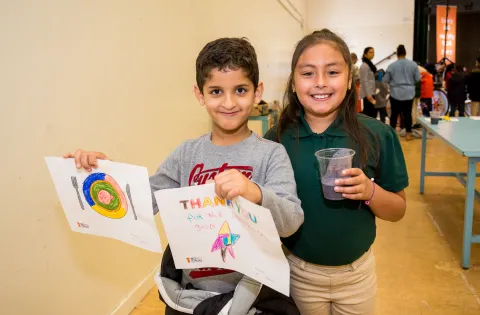 Boy and Girl. Boy holding thank you note and girl with cup of water