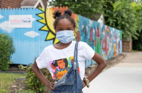 Black girl wearing as mask with hands on hips