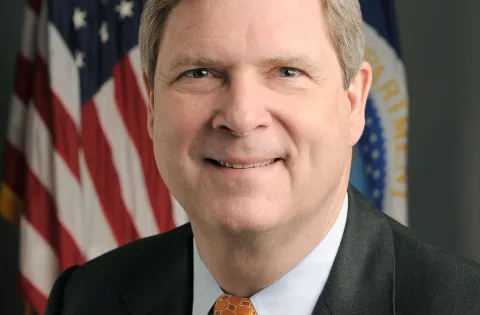 Government official with US flag in the back