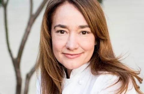 Andrea Reusing Photo. Woman wearing chefs cloths headshot