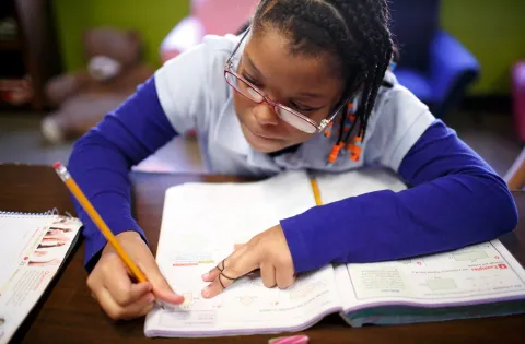 girl writing wearing purple sleeves