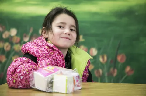 Girl wearing pink. Smiling and eating