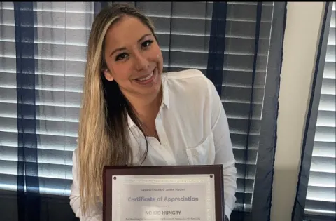 Andrea Cuellar holding recognitions 