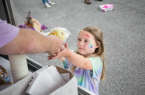 Little girl receives food from a summer meal site