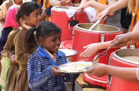 Girl picking up meal in India