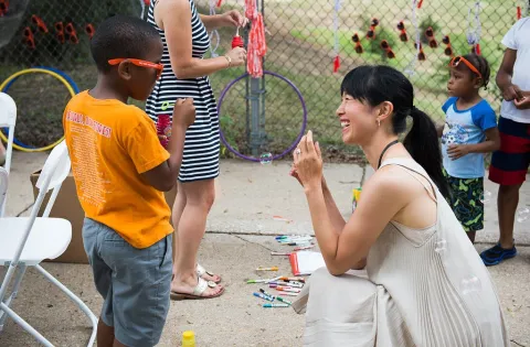 Woman approaching kid and kneeling