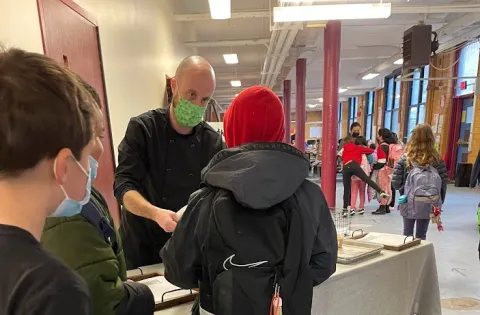 Chef passing a meal to a kid