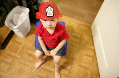 Toddler sitting with firefighter hat