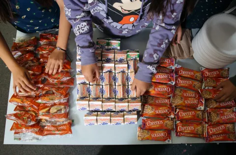 Bird's eye view of breakfast items and kids hands