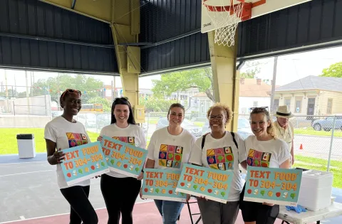 5 team members holding signs 304-304 for summer texting line