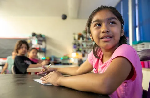 Latino girl in classroom paying attention