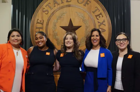 5 Latino women in front of Texas banner
