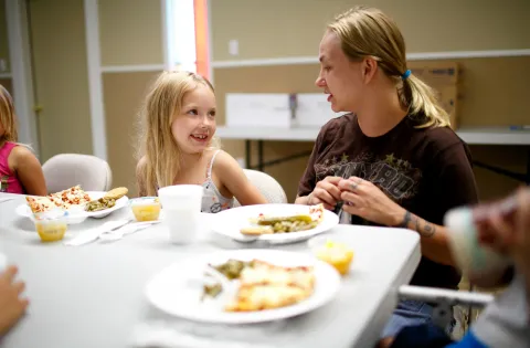 Child eating lunch with mother