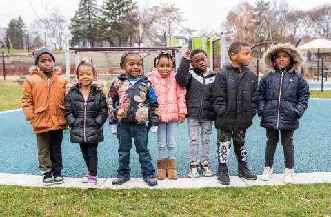 Row of young children in coats on playground