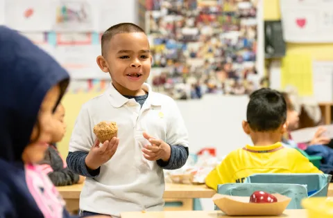 Little boy with breakfast in the classroom