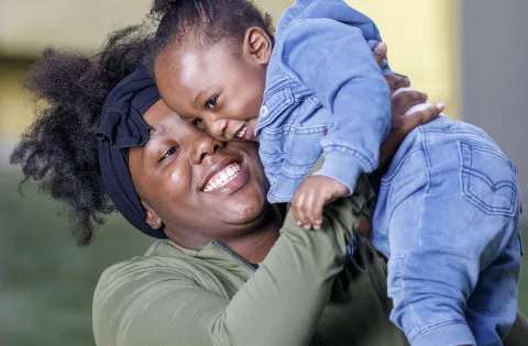 Mom holding child and smiling