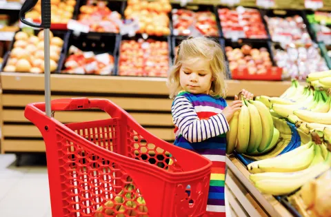 Little white girl holding bananas
