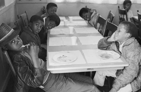 Black and white photo of children seated at meal site provided by Black Panthers