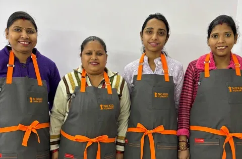 Four cooks in No Kid Hungry aprons