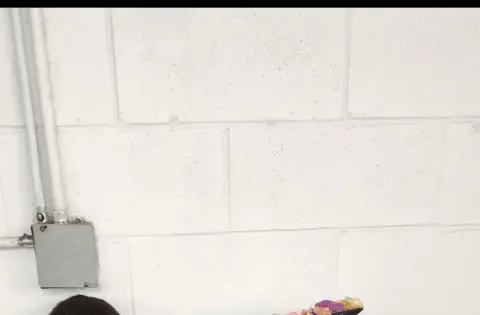 Mom wearing graduation gown with two kids