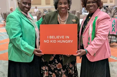 AKA's holding No Kid Hungry sign