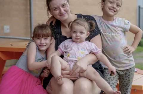 Mom at picnic table with three kids