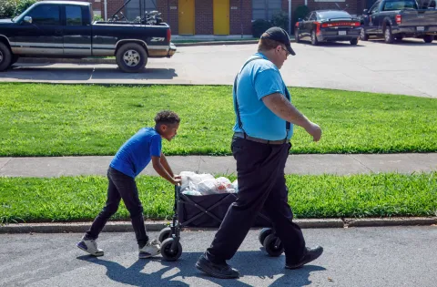 Man and kid pushing cart of food