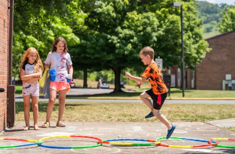 three children playing with hoops on the playground