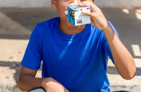 Boy in blue shirt drinking milk